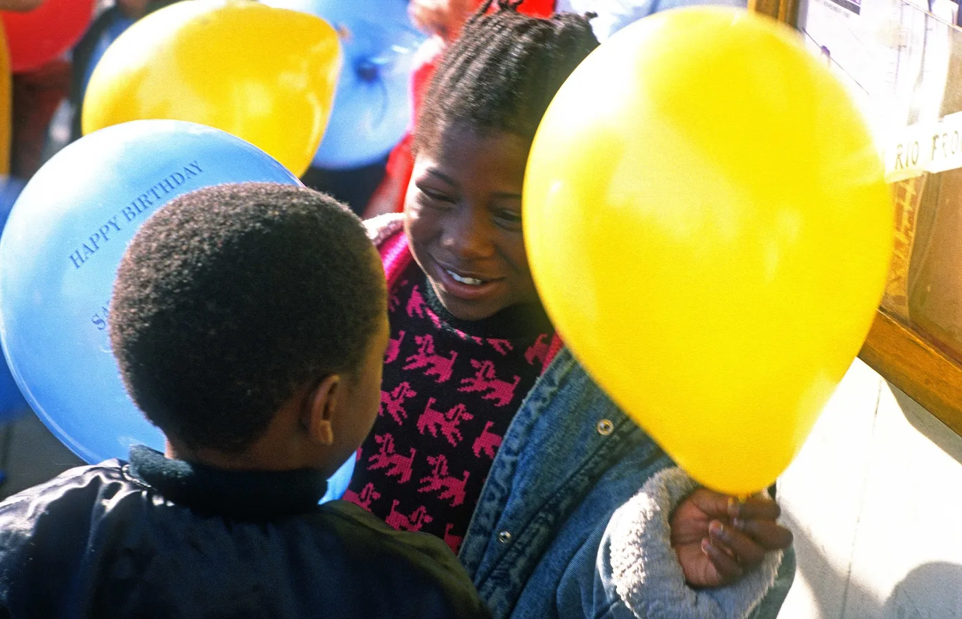 Children holding yellow and blue balloons
